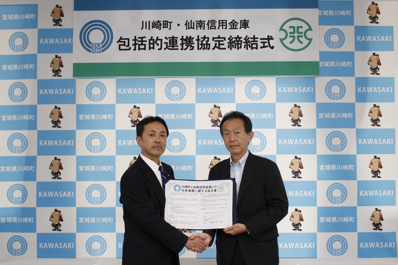 握手をする小山町長(左)と渡邊理事長(右)